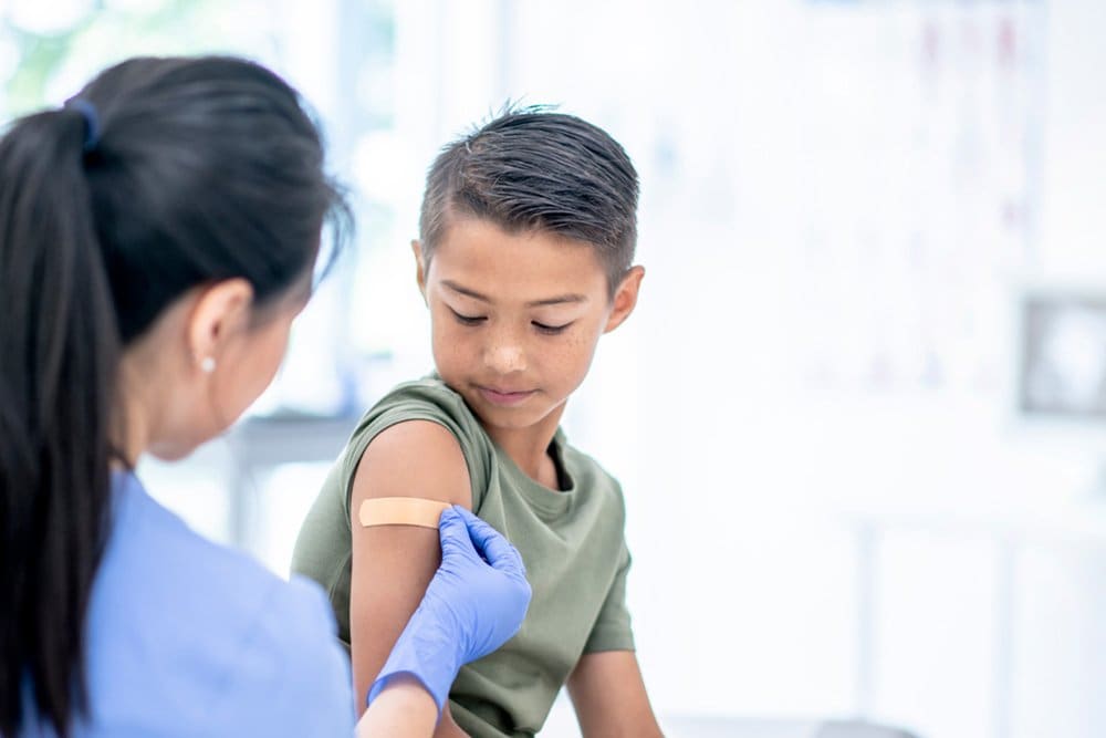 photo of a nurse putting a bandage on a boy's arm