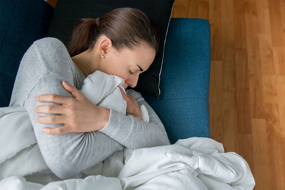 photo of a woman feeling sad laying on couch