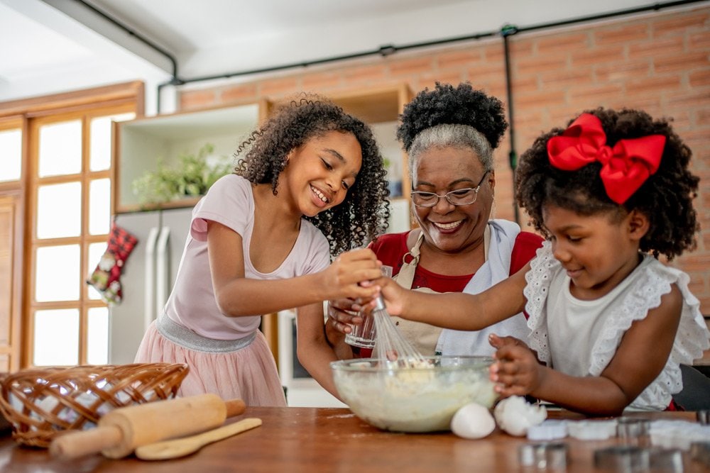 photo of a mature woman baking with 2 young girls in a kitchen