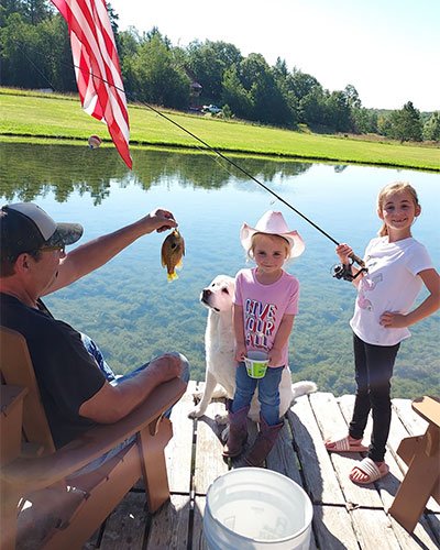 photo of Doug fishing with granddaughters on a dock