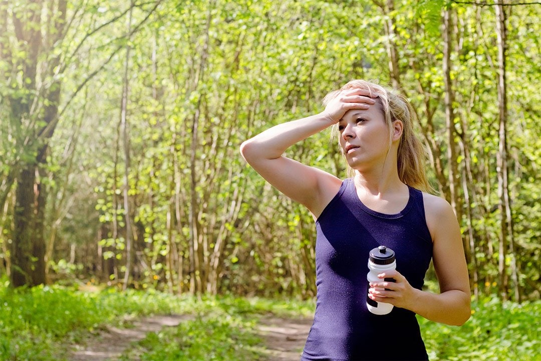 photo of a woman with a water bottle in her hand outdoor