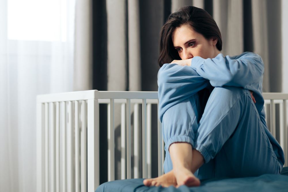 photo of a depress woman sitting on a bed