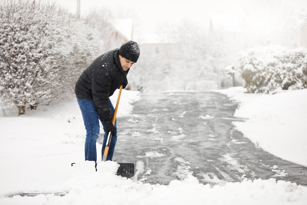 photo of a man shoveling driveway