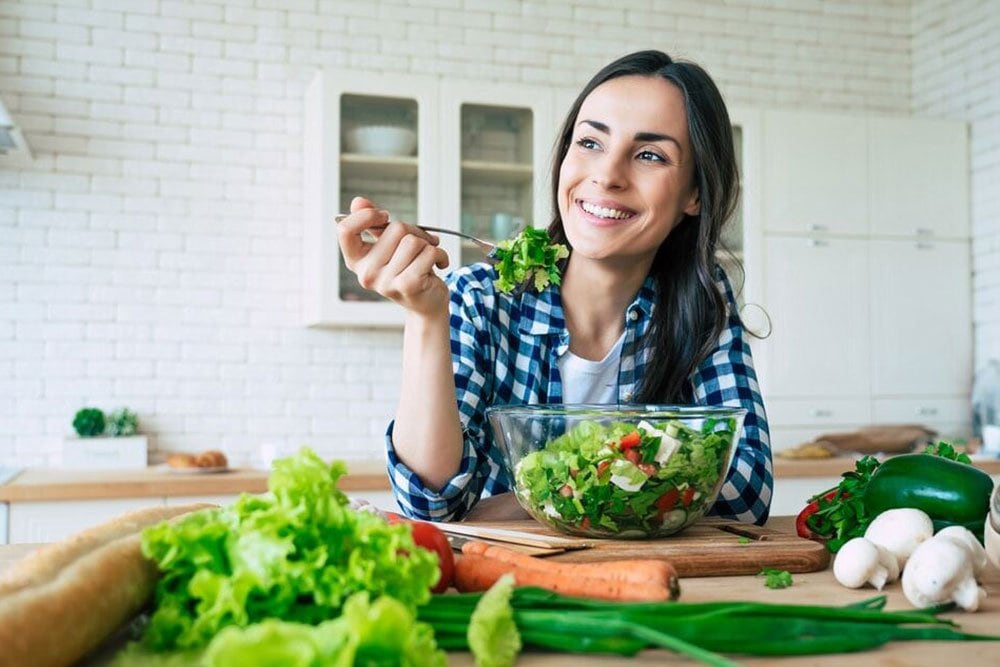 photo of a young woman enjpying a bowl of salad