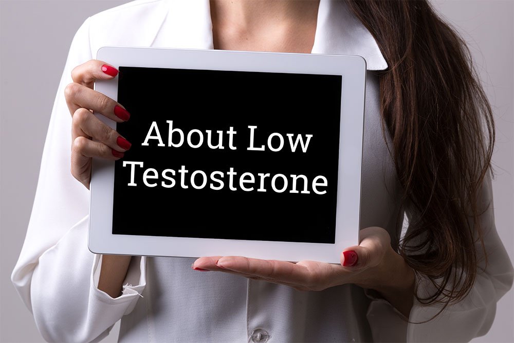 stock photo of a woman holding a sign that say About Low Testosterone