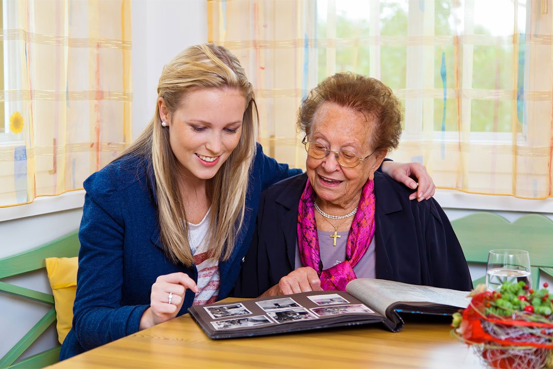 photo of a young woman browsing the photo album with an elderly woman