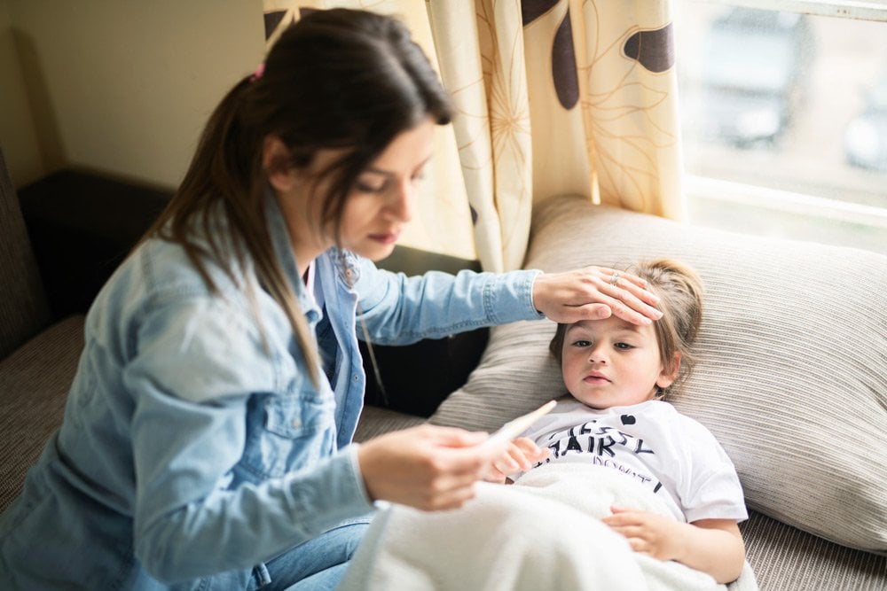 photo of a mom getting temperature reading of her kid