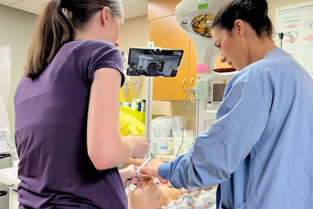 photo of 2 female staff operating a respiratory medical equipment