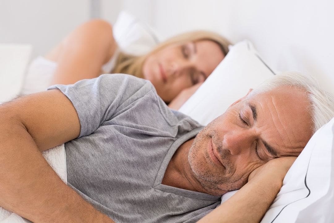 photo of a couple sleeping in bed