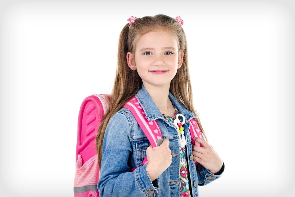 photo of a little girl carrying her backpack