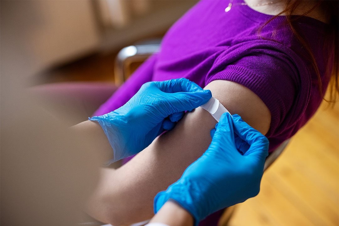 photo of a healthcare worker putting a bandage on a patient shoulder