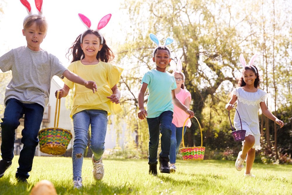 photo of some children with basket hunting Easter eggs outside