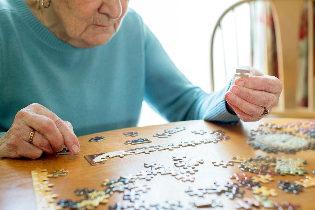 photo of an ederly woman playing puzzle