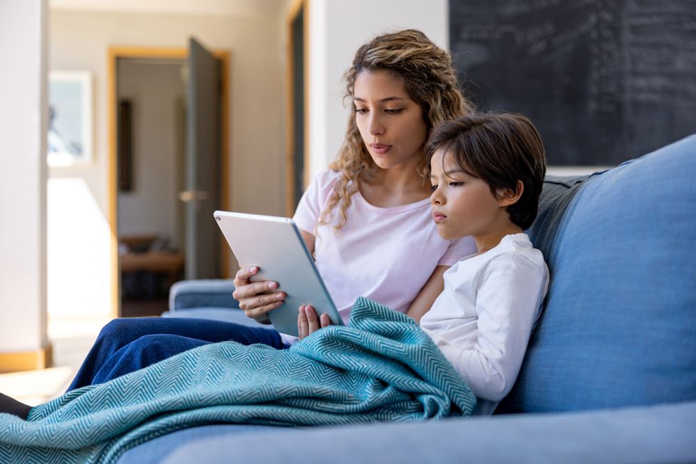 photo of a mom and young son browsing on a tablet together