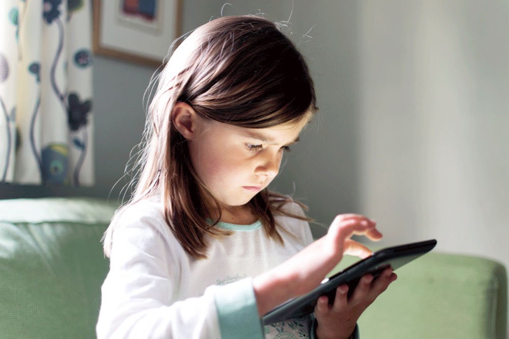 photo of a little girl using a tablet