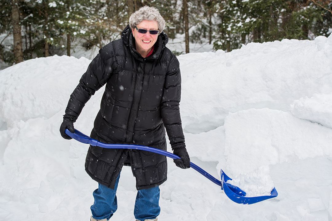 photo of a woman shoveling snow